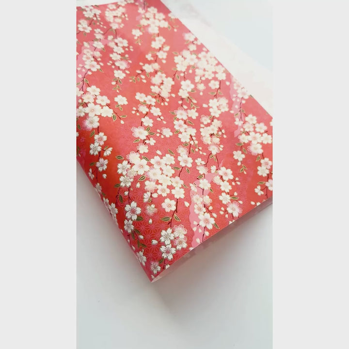 vidéo de démonstration du papier japonais yuzen chiyogami aux motifs de fleurs de cerisier et de motifs variés sur fond rouge orange adeline klam (M385)