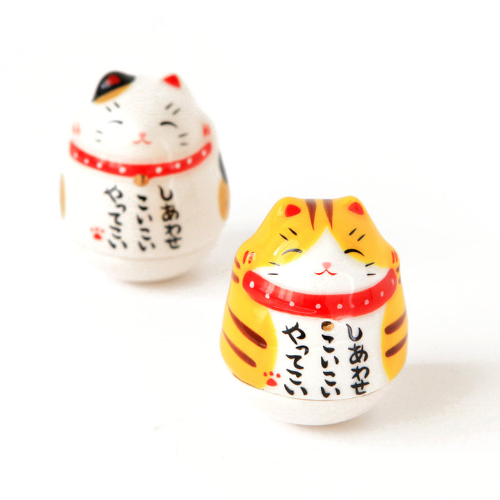 culbutos japonais en forme de maneki-neko au pelage tacheté noir, blanc et jaune et tigré jaune, blanc et marron