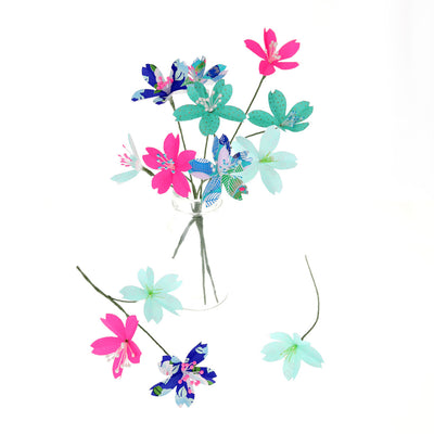 photo d'ambiance d'un kit bouquet fleurs de cerisier « fantastique » dans les tons bleu nuit, vert, rose fluo monté en bouquet
