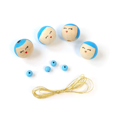 petites perles bleues, perles « visages » souriants aux détails bleus et fil doré